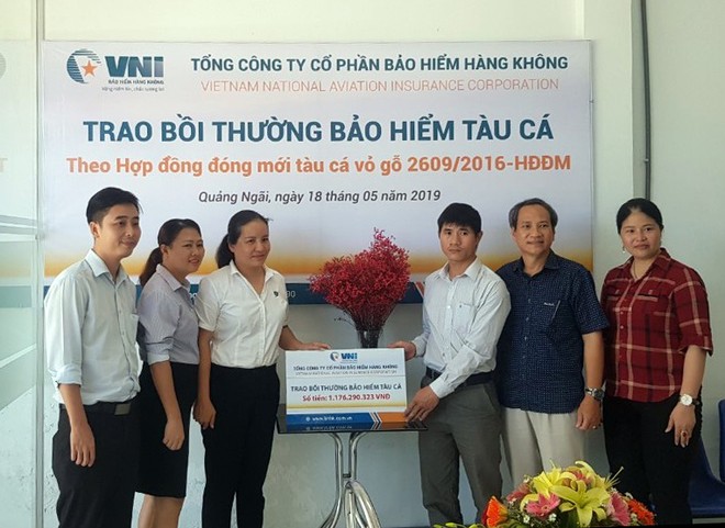 Bà Hà Thị Thu Trang - Giám đốc VNI Quảng Ngãi trao số tiền bồi thường tàu cá cho chủ tàu Võ Văn Dũng.