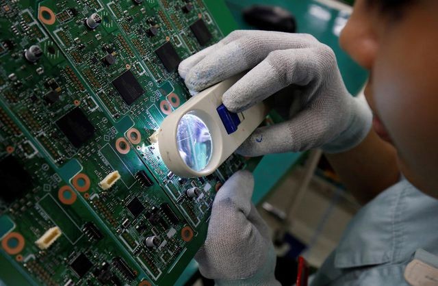 Một công nhân soát lỗi sản phẩm tại nhà máy ở Bắc Ninh, Việt Nam. (Ảnh: Reuters).