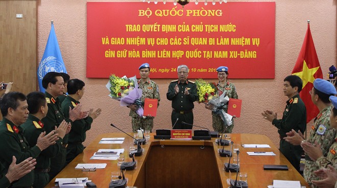 Thượng tướng Nguyễn Chí Vịnh trao quyết định và chúc mừng 2 sĩ quan lên đường làm nhiệm vụ. Ảnh BQP.