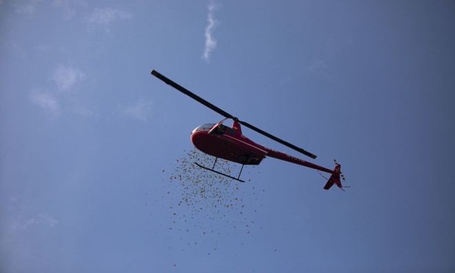Chiếc trực thăng thả những phong bì đỏ, lì xì cho các vị khách đến tham dự đám cưới. Ảnh: qq.