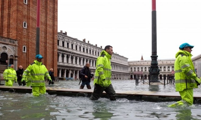 Công nhân dọn dẹp Quảng trường San Marco, Venice, Italy, sau khi nước lũ tiếp tục tấn công hôm 17/11. Reuters.
