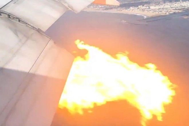 Động cơ chiếc Boeing 777 bị cháy nhìn từ cửa sổ máy bay - Ảnh: REUTERS