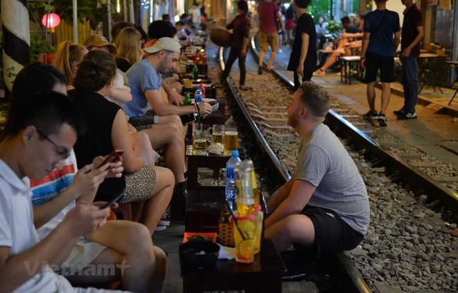 Trước khi bị đóng cửa, nhiều du khách đã đến Phố cà phê đường tàu để trải nghiệm cảm giác ngồi uống nước sát với đoàn tàu chạy qua. (Ảnh: Hoàng Anh/Vietnam+)