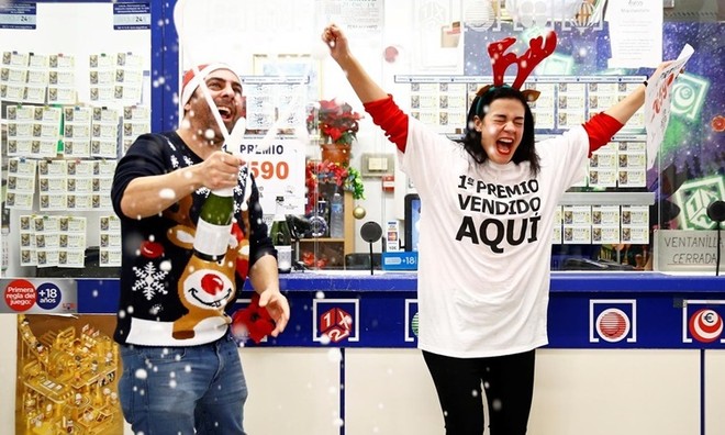 Hai chủ nhân của một gian hàng bán vé số mở rượu ăn mừng khi kết quả giải xổ số El Gordo được công bố ngày 22/12. Ảnh: Reuters.