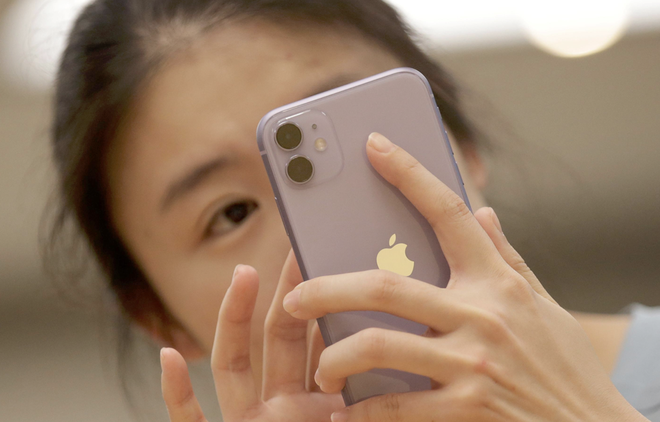 Một người tiêu dùng Trung Quốc sử dụng iPhone 11. (Nguồn: Reuters).