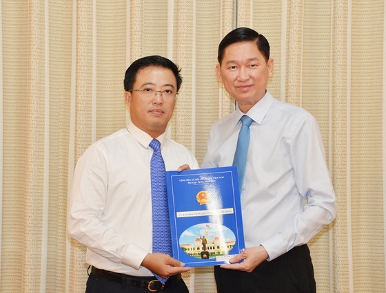 Ông Lê Huỳnh Minh Tú (trái) nhận quyết định bổ nhiệm giữ chức vụ Phó Giám đốc Sở Công thương TPHCM. Ảnh: Sài Gòn giải phóng online.