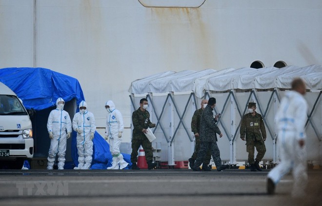 Nhân viên y tế làm nhiệm vụ gần du thuyền Diamond Princess bị cách ly tại cảng Yokohama, Nhật Bản ngày 13/2. (Ảnh: AFP/TTXVN).