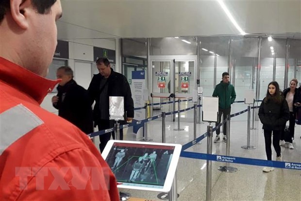 Nhân viên chữ thập đỏ dùng máy quét thân nhiệt để kiểm tra thân nhiệt hành khách tại sân bay Fiumicino, Rome, Italy, ngày 5/2/2020. (Ảnh: AFP/ TTXVN).