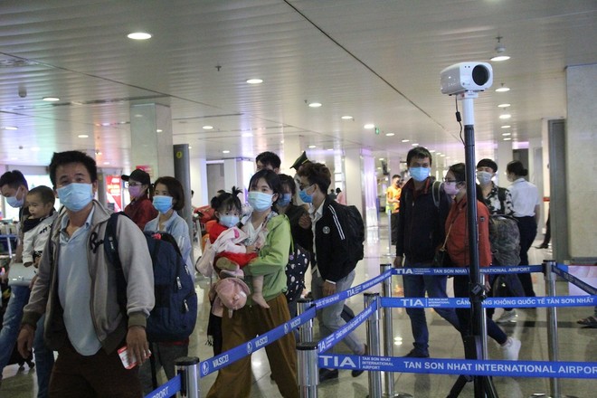 Hành khách qua chốt kiểm soát virus corona tại sân bay Tân Sơn Nhất.