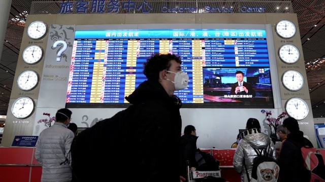 Hành khách đeo khẩu trang tại sân bay Bắc Kinh. (Ảnh: Reuters).