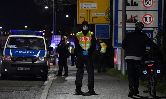 Một cảnh sát Đức đứng gác tại khu vực kiểm soát phương tiện giữa thành phố Kehl, Đức và Strasbourg, Pháp ngày 12/3. Ảnh: AFP.