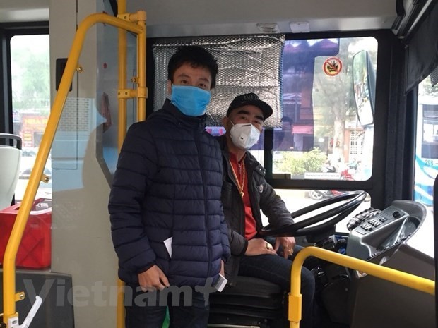 Tài xế và nhân viên phụ xe buýt tại Hà Nội đeo khẩu trang phòng chống dịch COVID-19. (Ảnh: CTV/Vietnam+).