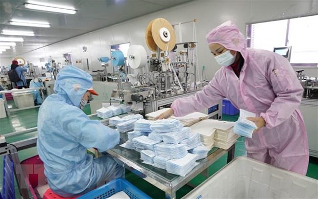 Công nhân nỗ lực may khẩu trang y tế tại một nhà máy ở Vũ Hán, Trung Quốc. (Ảnh: THX/TTXVN).