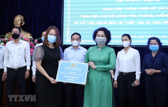 Đại diện Tập đoàn Vạn Thịnh Phát (trái) trao tượng trưng số tiền ủng hộ cho Ủy ban Mặt trận Tổ quốc Việt Nam trong lễ phát động ủng hộ công tác phòng, chống dịch COVID-19 và ủng hộ đồng bào bị hạn hán, xâm nhập mặn. (Ảnh: TTXVN).