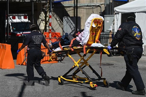 Nhân viên y tế chuyển bệnh nhân nhiễm COVID-19 tới trung tâm y tế Brooklyn, New York, Mỹ. (Ảnh: AFP/TTXVN).