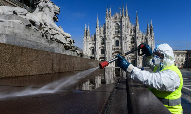 Nhân viên vệ sinh Italy phun khử trùng quảng trường Piazza ở Milan ngày 31/3. Ảnh: AFP.