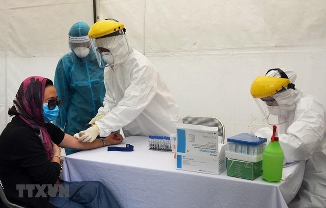 Lấy mẫu xét nghiệm virus SARS-CoV-2 cho người dân tại trạm xét nghiệm nhanh quận Ba Đình. (Ảnh: TTXVN phát).