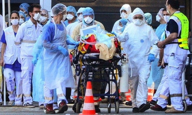 Nhân viên y tế di chuyển người nhiễm nCoV tại Pháp ngày 10/4. Ảnh: AFP.