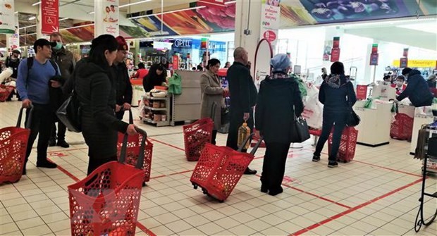 Xếp hàng giãn cách theo vạch kẻ trước quầy thanh toán tại một siêu thị ở thủ đô Moskva (Nga).