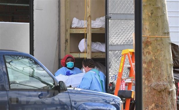 Nhân viên y tế chuyển thi thể bệnh nhân COVID-19 từ một nhà xác dã chiến tới Trung tâm y tế Do thái Kingsbrook ở Brooklyn, New York, Mỹ. (Ảnh: AFP/TTXVN).