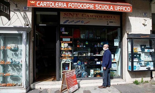 Người dân đứng trước một cửa hàng ở thành phố Catania, Italy hôm nay, sau khi chính phủ cho phép một số nơi mở cửa lại. Ảnh: Reuters.