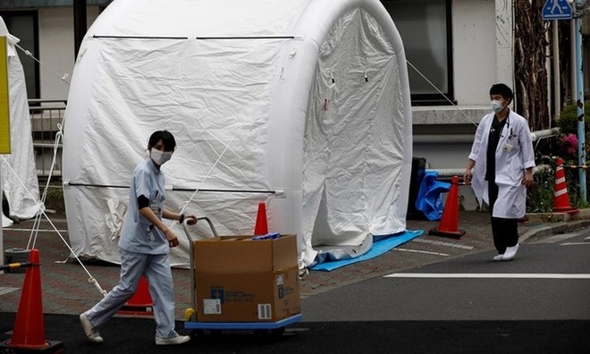 Nhân viên y tế bước qua một chiếc lều dùng để xét nghiệm nCoV tại bệnh viện đa khoa Kawakita ở Tokyo, Nhật Bản, ngày 17/4. Ảnh: Reuters.