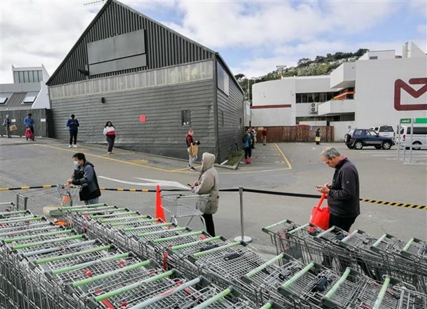 Người dân thực hiện giãn cách xã hội để phòng tránh lây nhiễm COVID-19 khi xếp hàng vào siêu thị tại Wellington, New Zealand ngày 11/4/2020. (Ảnh: THX/ TTXVN).