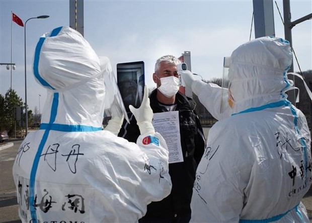 Nhân viên y tế Trung Quốc kiểm tra thân nhiệt ngăn chặn sự lây lan của dịch COVID-19 tại một trạm kiểm tra hải quan ở Suifenhe, tỉnh Hắc Long Giang, gần biên giới với Nga, ngày 1/5/2020. (Ảnh: AFP/TTXVN).