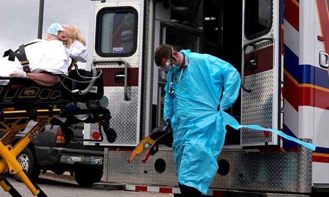 Nhân viên y tế chuẩn bị đưa bệnh nhân Covid-19 lên xe cứu thương ở Oklahoma, Mỹ, tháng trước. Ảnh: Reuters.
