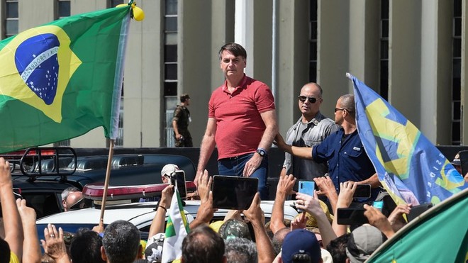 Tổng thống Brazil Bolsonaro (áo đỏ) giữa những người biểu tình phản đối các chính sách thắt chặt phòng, chống dịch Covid-19. Ảnh: AFP/Getty Images.