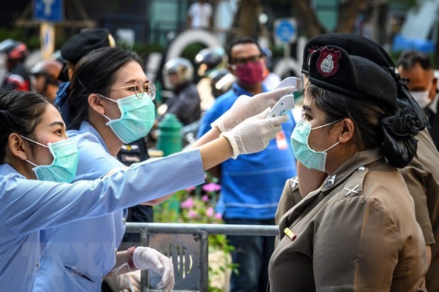 Nhân viên y tế kiểm tra thân nhiệt cho cảnh sát ở Bangkok, Thái Lan. (Nguồn: AFP/TTXVN).