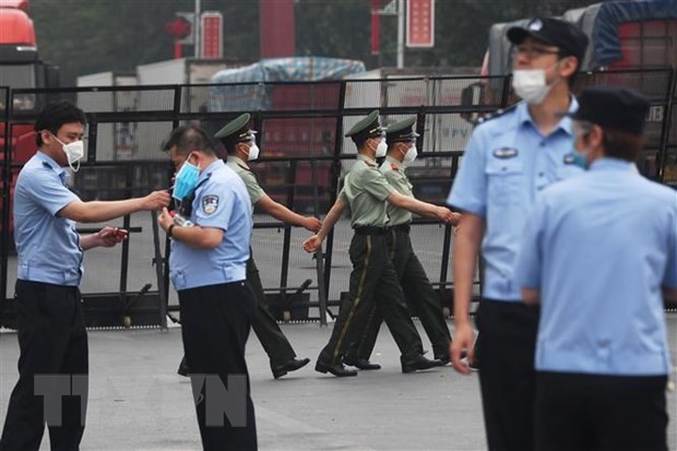 Cảnh sát gác tại lối vào chợ Tân Phát Địa ở Bắc Kinh, Trung Quốc, ngày 13/6, sau khi chợ phải đóng cửa do phát hiện ca nhiễm COVID-19 mới. (Ảnh: AFP/TTXVN).