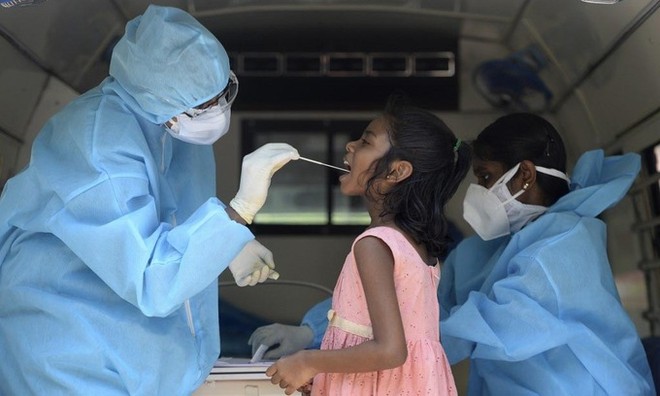 Nhân viên y tế lấy mẫu xét nghiệm nCoV cho một bé gái tại thành phố Chennai, Ấn Độ, hôm 16/6. Ảnh: AFP.