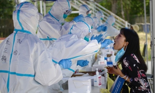 Nhân viên y tế lấy mẫu xét nghiệm nCoV cho một người dân ở thủ đô Bắc Kinh, Trung Quốc, ngày 20/6. Ảnh: Reuters.