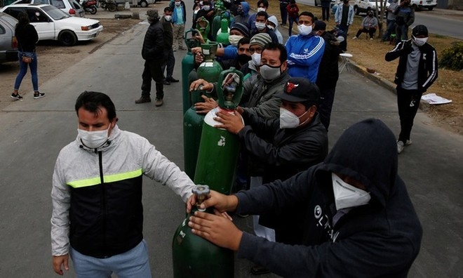 Người dân đeo khẩu trang xếp hàng chờ bên ngoài một cửa hàng phân phối oxy ở thủ đô Lima, Peru hôm 25/6. Ảnh: Reuters.