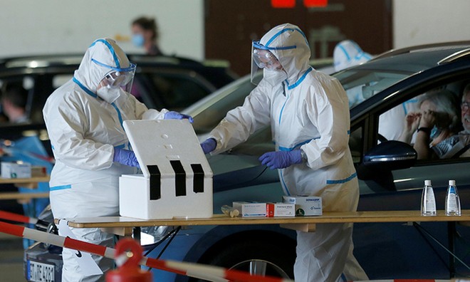 Nhân viên y tế lấy mẫu xét nghiệm nCoV trong nhà chứa máy bay của sân bay Guetersloh, Đức, ngày 27/6. Ảnh: Reuters.