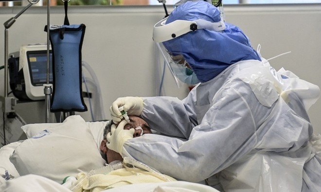 Y tá nhỏ thuốc mắt cho bệnh nhân Covid-19 tại Colombia ngày 8/7. Ảnh: AFP.