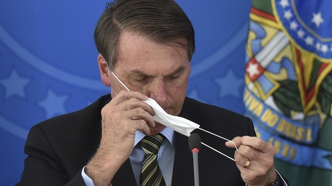 Tổng thống Jair Bolsonaro tháo khẩu trang trong cuộc họp báo. Ảnh: AP.