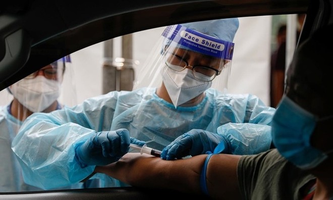 Nhân viên y tế lấy mẫu máu tại một điểm xét nghiệm nCoV trên ôtô ở thủ đô Manila, Philippines, ngày 15/7. Ảnh: Reuters.