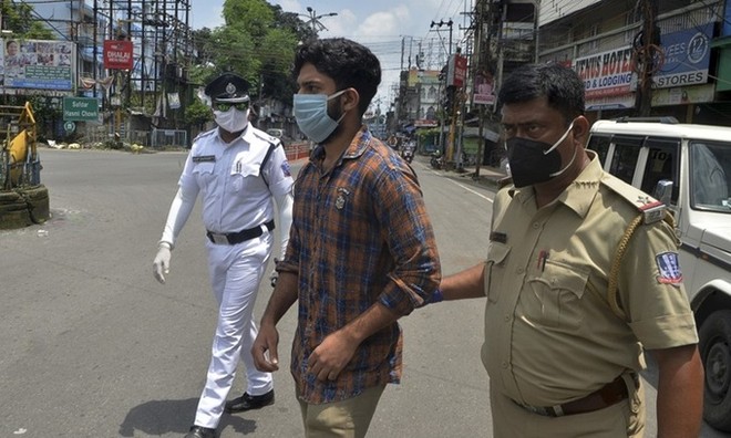 Cảnh sát Ấn Độ bắt một người đàn ông (giữa) vi phạm lệnh phong tỏa ngăn Covid-19 tại thành phố Siliguri, bang Tây Bengal hôm 25/7. Ảnh: AFP.