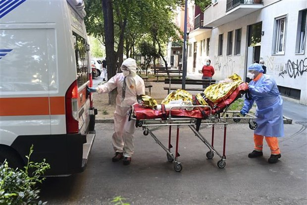 Nhân viên y tế chuyển bệnh nhân COVID-19 tới bệnh viện tại Milan, Italy. (Ảnh: AFP/TTXVN).