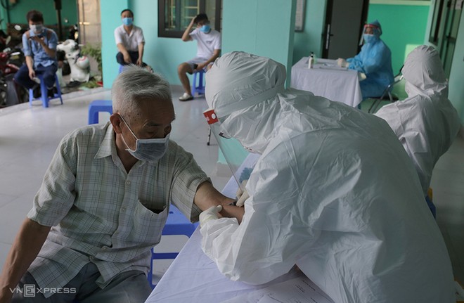 Nhân viên y tế phường Yên Hòa, quận Cầu Giấy lấy mẫu máu xét nghiệm cho người về từ Đà Nẵng ngày 30/7.