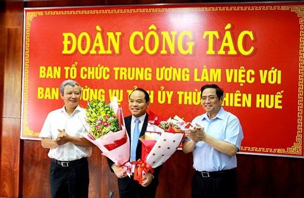 Trưởng ban Tổ chức Trung ương Phạm Minh Chính (bìa phải) và Bí thư Tỉnh ủy Thừa Thiên Huế Lê Trường Lưu (bìa trái) tặng hoa chúc mừng ông Nguyễn Quốc Đoàn.