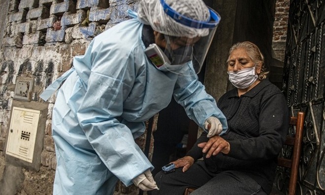 Nhân viên Bộ Y tế Peru kiểm tra và xét nghiệm Covid-19 cho một phụ nữ ở thủ đô Lima hôm 20/8. Ảnh: AFP.