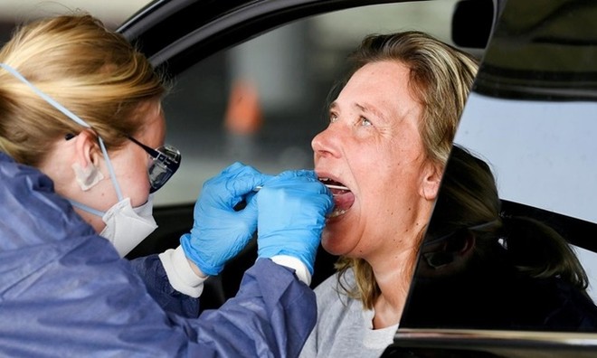 Nhân viên y tế lấy mẫu xét nghiệm nCoV tại một trạm kiểm tra trong xe ôtô ở Alkmaar, Hà Lan, hồi tháng 4. Ảnh: Reuters.