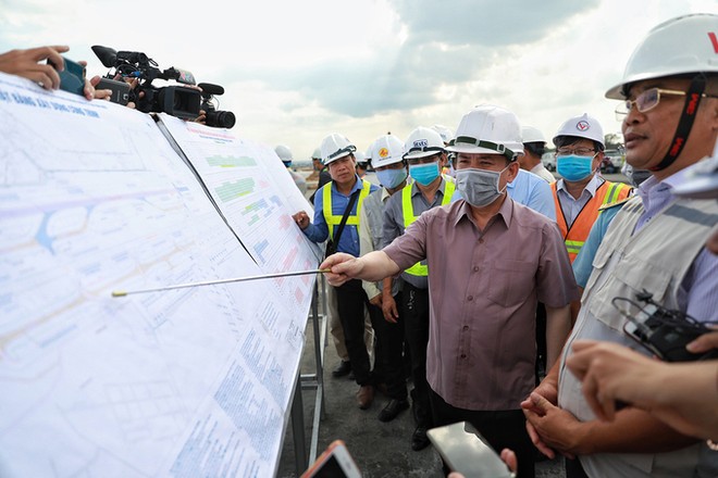 Bộ trưởng Giao thông Vận tải Nguyễn Văn Thể chỉ vào bản đồ sân bay và vị trí thi công tại dự án cải tạo đường băng 25R/07L Tân Sơn Nhất, chiều 29/8. 