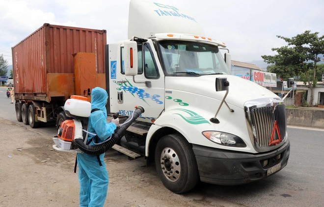 Nhân viên y tế phun thuốc khử khuẩn đối với những xe chở hàng hóa đến từ vùng dịch bệnh tại chốt kiểm soát dịch bệnh số 6 của Thừa Thiên-Huế. (Ảnh: Đỗ Trưởng/TTXVN).
