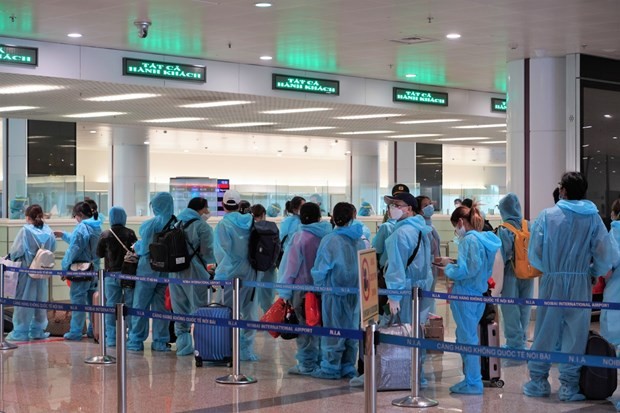 Hành khách trên chuyến bay quốc tế thương mại tới Việt Nam đầu tiên sau thời gian dài vì dịch COVID-19 làm thủ tục nhập cảnh tại sân bay Nội Bài. (Ảnh: CTV/Vietnam+).