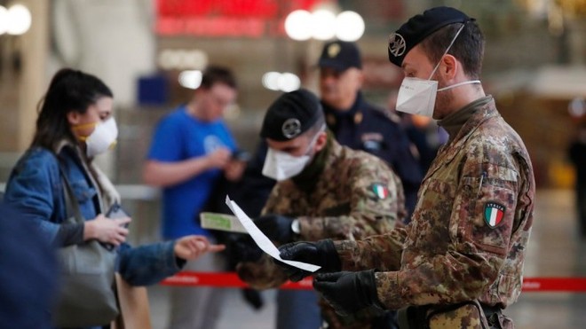 Cảnh sát và quân đội kiểm tra hành khách tại một nhà ga ở Milan, Italy. Ảnh: AP.