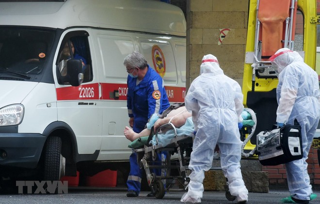 Nhân viên y tế chuyển bệnh nhân mắc COVID-19 lên xe cứu thương tại Saint Petersburg, Nga ngày 5/10/2020. (Ảnh: AFP/TTXVN).